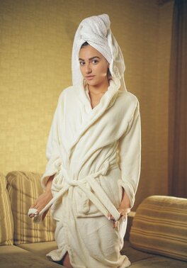 Whore with a towel on head and in white robe gives sexual pleasure to pussy