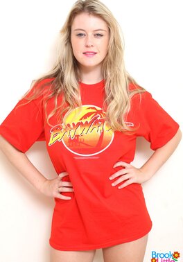 Girl takes her red T-shirt and black shorts off but leaves shoes and panties on