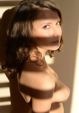 Drop-dead gorgeous teen brunette models all naked by the window blind