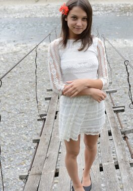 Frisky girl enjoys posing naked on top of a suspension bridge