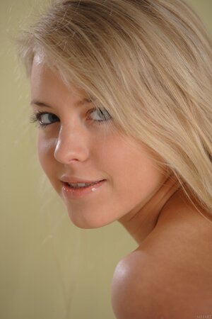 Young woman knows her job and simply takes blue shirt down posing naked