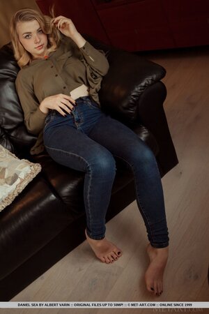 Teen honey amazes with her big natural tits and flashes pussy on the black couch