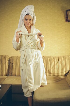 Dark-haired teen gets rid oа the towel and robe and relaxes after bathing time