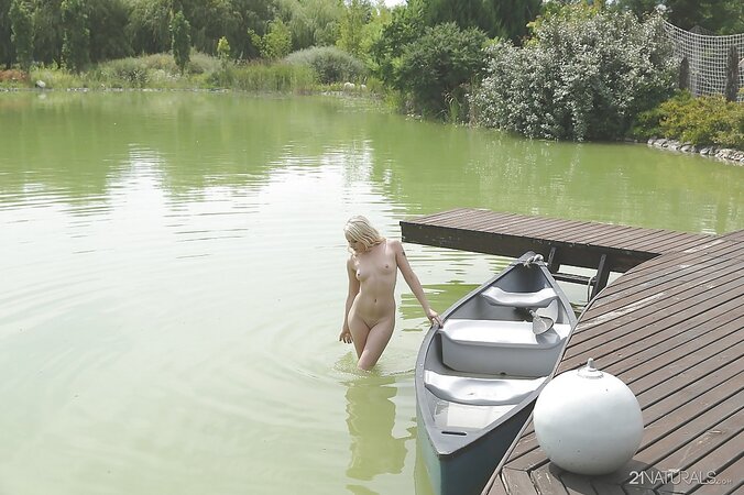 Slutty blonde girl in a birthday suit rests by a lake and masturbates