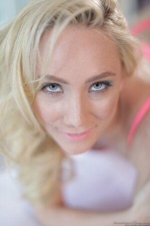 Big-assed blonde seductively takes off pink lingerie exposing her assets
