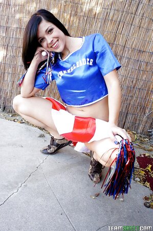Black-haired cheerleader goes outdoors to perform solo strip show in backyard