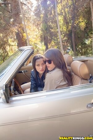 Two excited girlfriends find quiet spot perfect to have fun in roadster