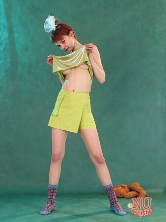 Babe with red hair in fancy green outfit masturbates in a vaginal way