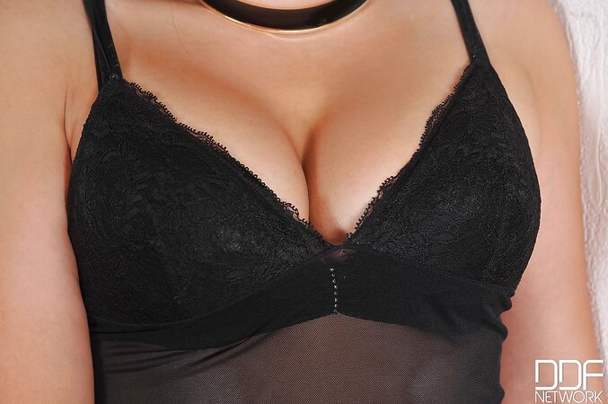 MILF in black demonstrates breasts and sweet ass slowly stripping on camera