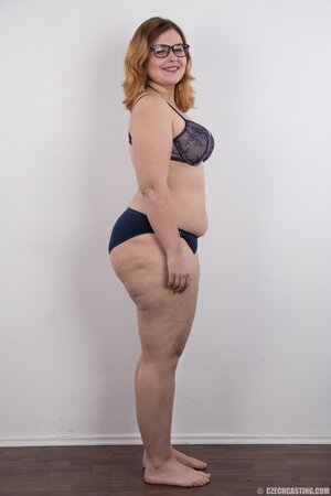 Fat whore with glasses rocks out in the porn studio trying striptease skills out