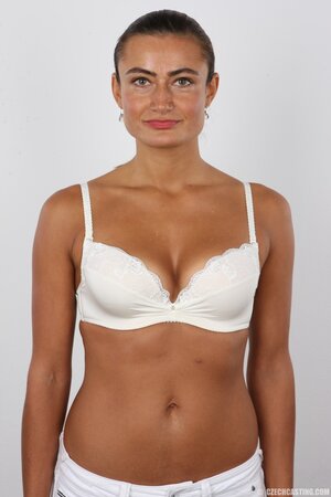 Female with green eyes wears white pants and bra but black panties at photoshoot