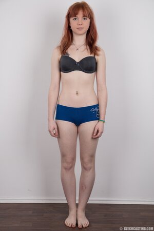 Female with red hair and colored rose tattooed on pale body strips down