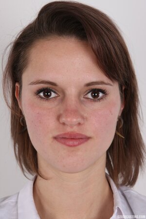 Female smiles so shy but still keeps on stripping naked in photo studio