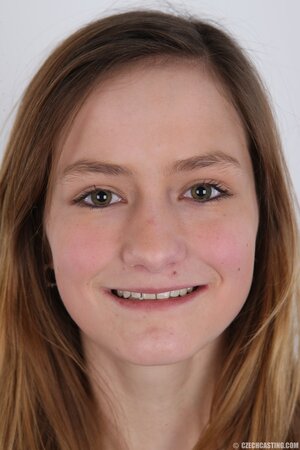 Young woman with different smile deletes sweater and jeans to stay bared