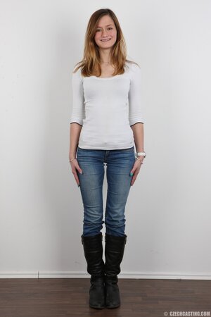 Young woman with different smile deletes sweater and jeans to stay bared