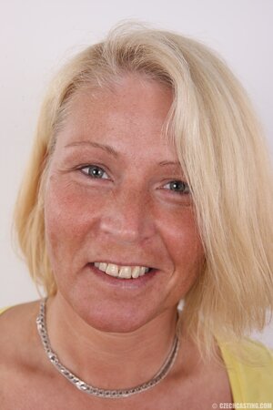 Photographer takes pictures of cheerful mature woman with blonde hair