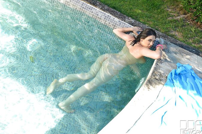 Joyful brunette with huge saggy tits poses completely naked by poolside