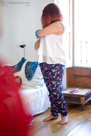 Plus-sized redhead on pink lingerie to get fully dressed next to the window
