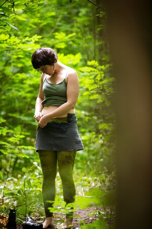 Chubby chick with glasses puts on her clothes after posing nude in the wood
