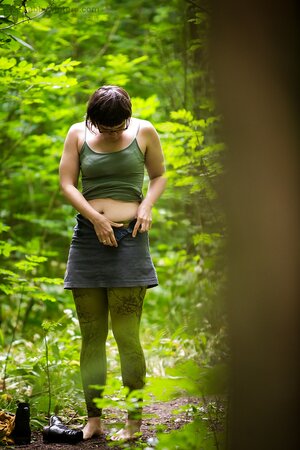 Chubby chick with glasses puts on her clothes after posing nude in the wood