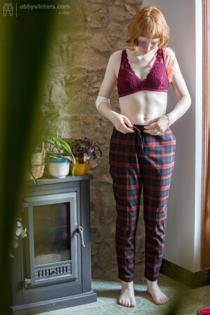Pale redhead chick covers natural boobs with burgundy lingerie on the spy camera