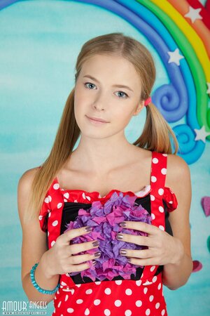 Young woman in a polka-got red dress gets nude in her infantile room
