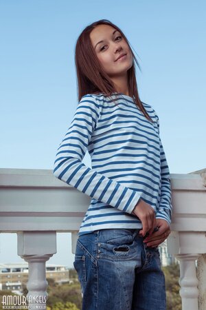 Woman in striped top and jeans takes them off exposing her tan lines