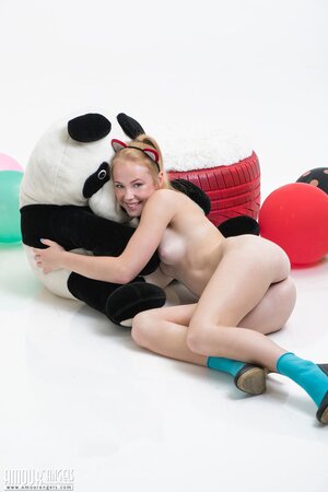 Love with pussy ears hugs and rides a plush panda with balloons in her hands