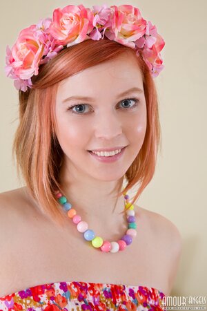 Red-haired cutie seductively takes off sweet dress and poses nude near table