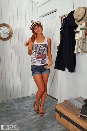 Skinny redhead adores marine theme and posing naked on the wooden table