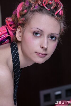 Euro minx with dreadlocks poses in the bedroom dressed only in a sexy necktie