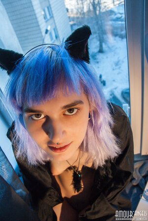 Shy alt girl while sitting near window seductively demonstrates tits and pussy