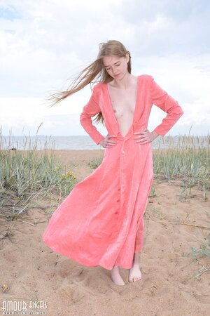 Skinny babe walks naked around spacious field dressed only in a sexy dress