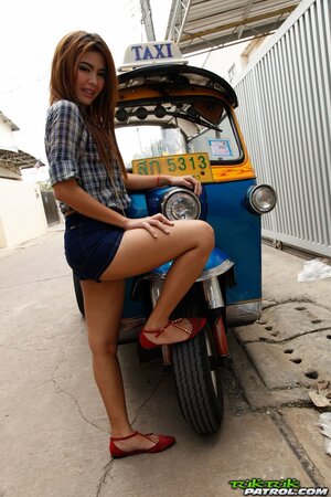 Exotic teen with red hair demonstrates her braces while posing near rickshaw