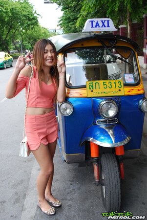 Joyful Thai minx poses near white fellow and his impressive auto rickshaw