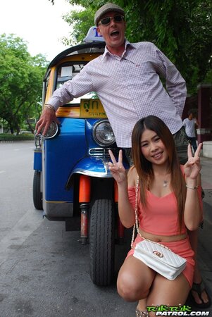 Joyful Thai minx poses near white fellow and his impressive auto rickshaw