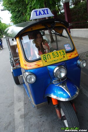 Joyful Thai minx poses near white fellow and his impressive auto rickshaw