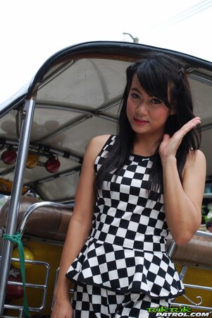 Inviting Thai model in a checkered dress gets into the Tuk Tuk Taxi