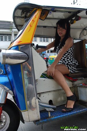 Inviting Thai model in a checkered dress gets into the Tuk Tuk Taxi