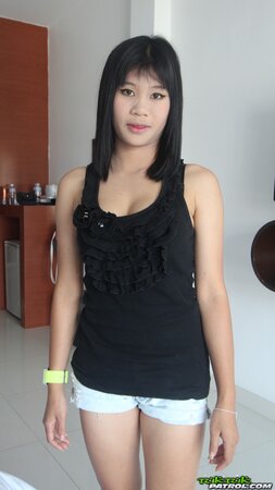 Young Eastern woman with a wide smile exposes small tits and shaved vagina