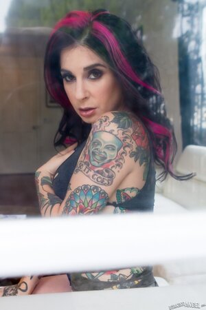 Porn queen strips in front of the glass door and continues posing on the sofa