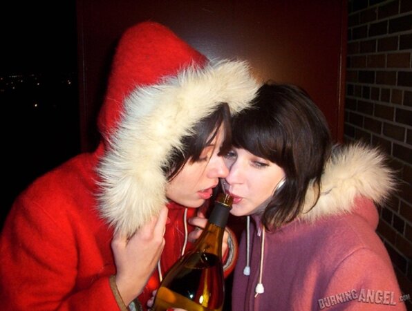 Lovely girls drink beer outdoors and this makes them eager to touch each other