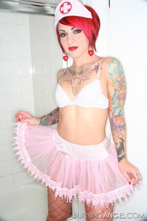 Nurse with red hair and meaningful tattoos over her body touches her cunt