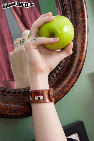 Tattooed coed with green locks eats an apple and fingers vagina on the floor
