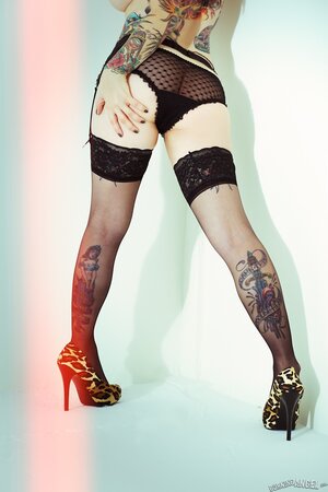 Tattooed MILF with great body takes off lingerie and poses only in stockings