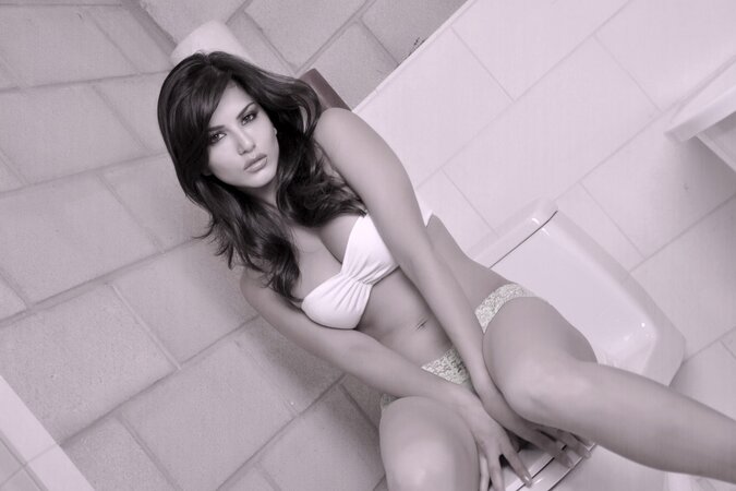 Charming Sunny Leone in white underwear exposes her body on the toilet