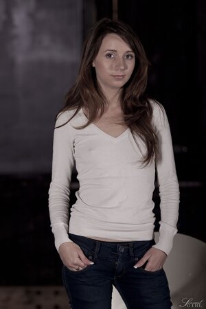 Black-haired gal strips naked in strange spacious room with a white chair