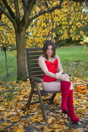 Nice young chick takes off red corset outdoors in honor of Halloween