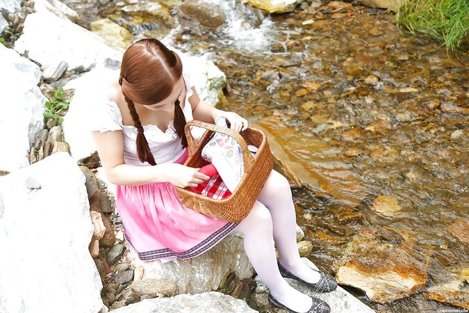 Girl with two pigtails has big dildo in ped for self-satisfaction on the rocks