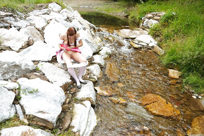 Girl with two pigtails has big dildo in ped for self-satisfaction on the rocks